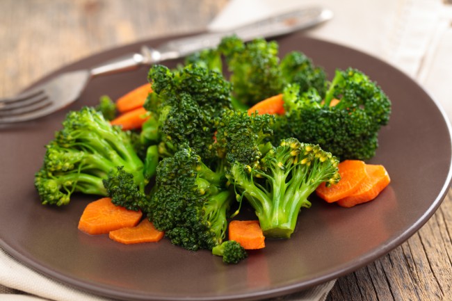 Bucati de broccoli si morcovi pe o farfurie