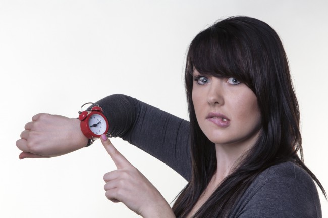 Femeie ingrijorata cu ceas la mana