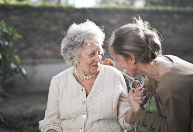 Imagine cu o femeie bătrână și una tânără care vorbesc