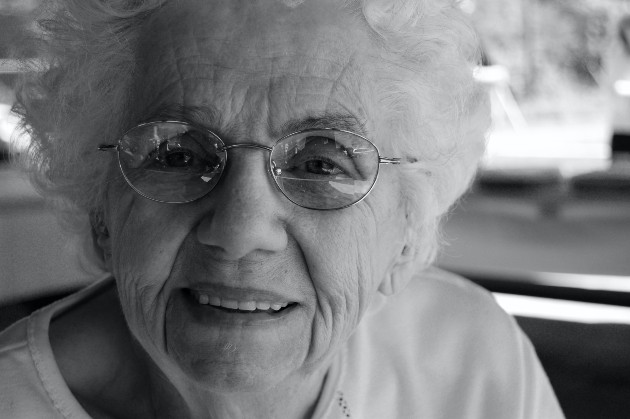 Imagine alb-negru cu o femeie bătrână care zâmbește