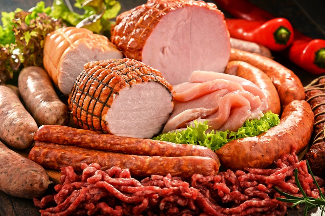 muschi de porc, carnati de porc, slanina de porc si carne tocata de porc, asezate pe mai multe foi de salata, alaturi de ardei rosii