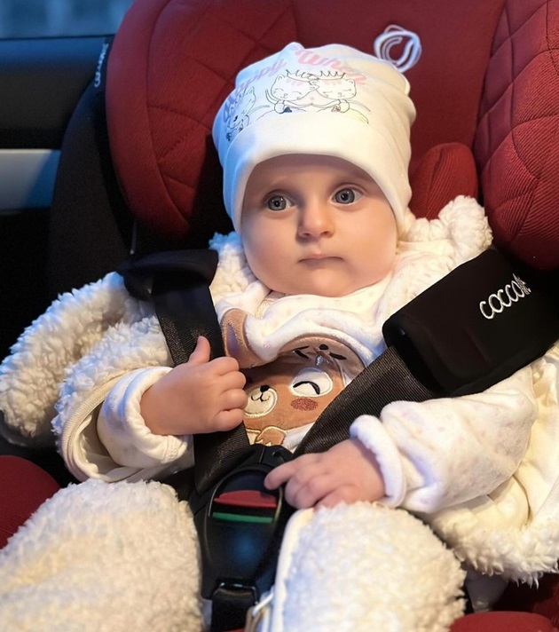 Fiica Crinei Matei, Charlotte, într-un scaun de mașină, îmbrăcată corespunzător pentru iarnă