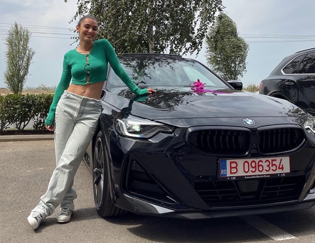 Alexia Eram îmbrăcată casual, lângă noua sa masină, marca BMW, în ziua când a cumpărat-o