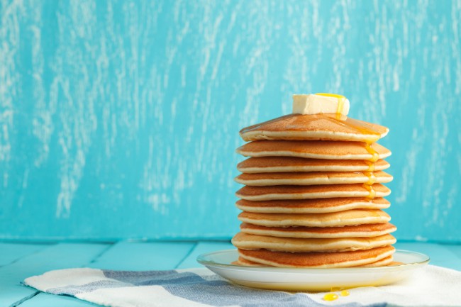 pancakes pe fundal albastru servite cu unt si mier