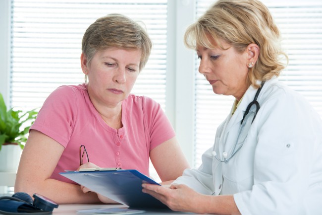 femeie care consulta medicul in vederea efectuarii unor analize medicale
