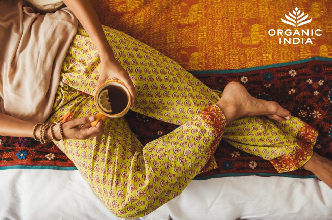 femeie in pijamale cu cana de ceai