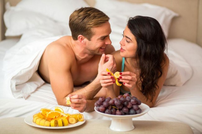 cuplu in pat care mananca fructe