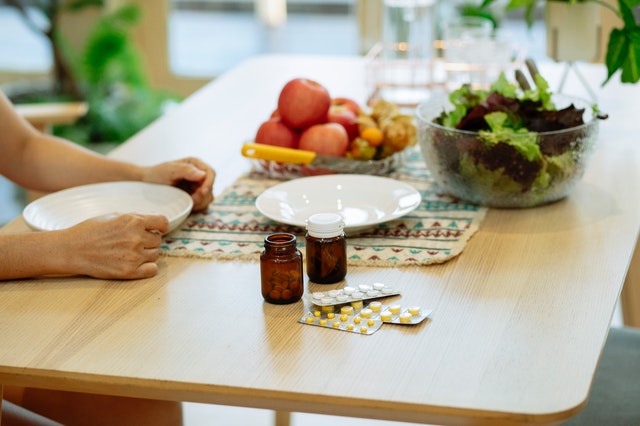 Alimente și medicamente așezate pe o masă