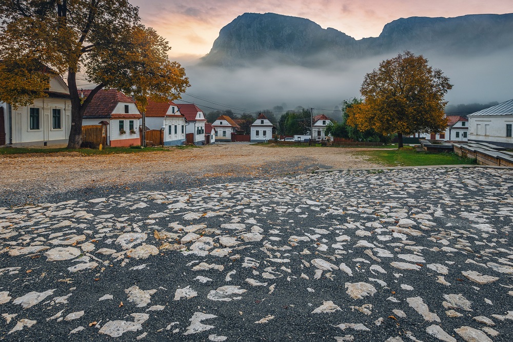 Case albe și muntele Piatra Secuiului în fundal la răsărit, în Rimetea, județul Alba, Transilvania, România, Europa.