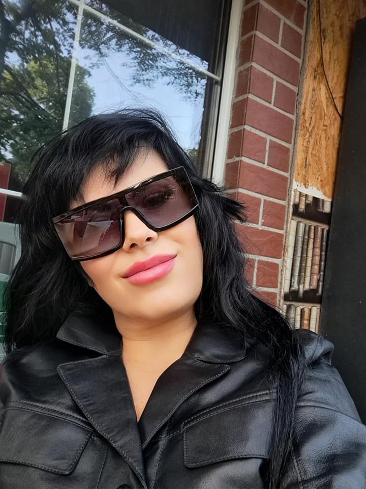 Mariana Moculescu îmbrăcată într-o jachetă neagră de piele, purtând o pereche de ochelari de soare în aceeași culoare