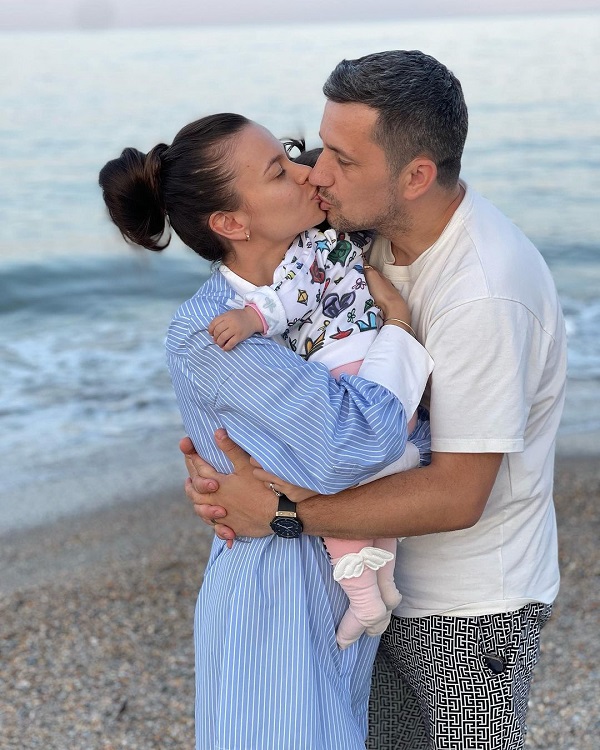 Flick și Denisa Filcea se sărută pe plajă, în timp ce o țin în brațe pe fiica lor, Eva-Maria
