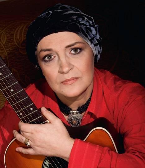 Tatiana Stepa cu un turban pe cap și cu o chitară în brațe