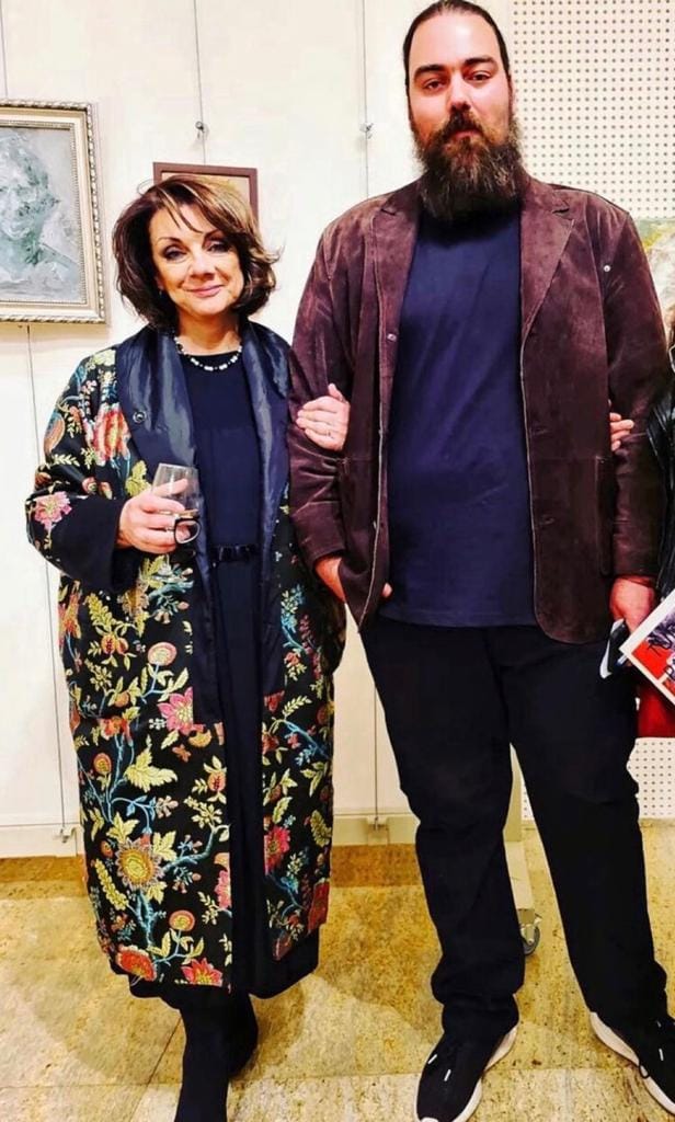 Carmen Tănase cu un pahar de șampanie în mână, alături de fiul ei la una dintre expozițiile lui