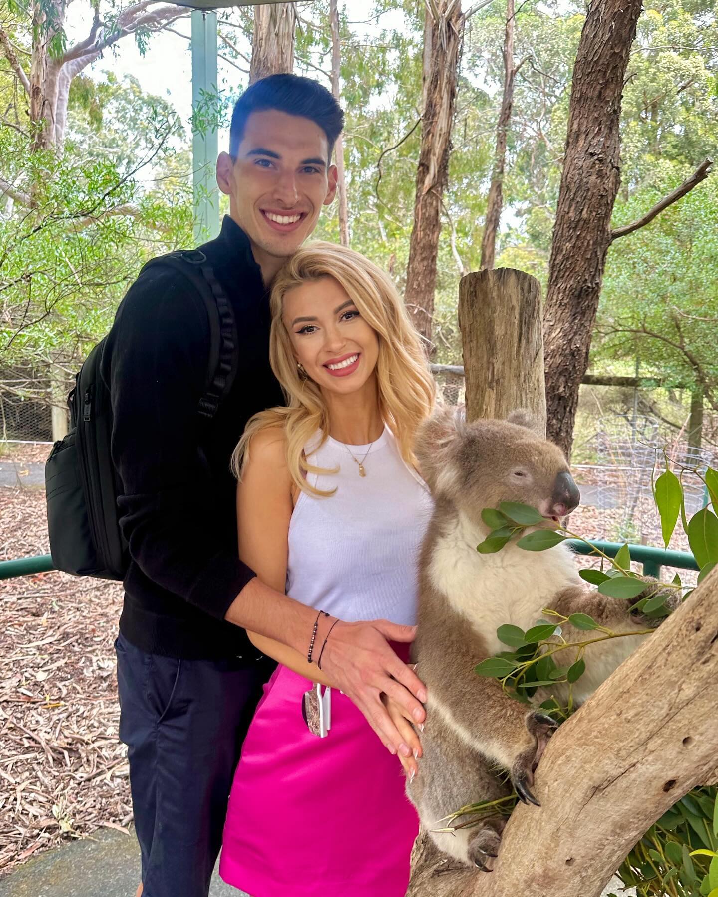 Andreea Bălan alături de Victor Cornea, la grădina zoologică, îmbrățișând un urs koala