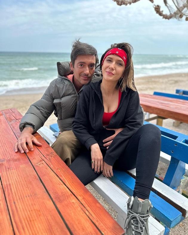 Adela Popescu și Radu Vâlcan, îmbrățișați, pe o bancă aflată pe plajă