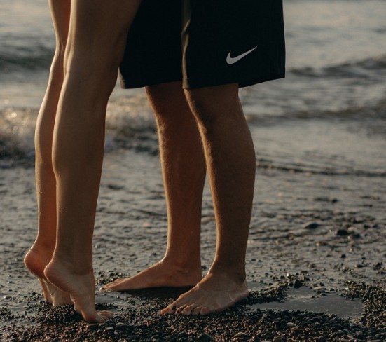 Picioare de barbat si femeie pe plaja