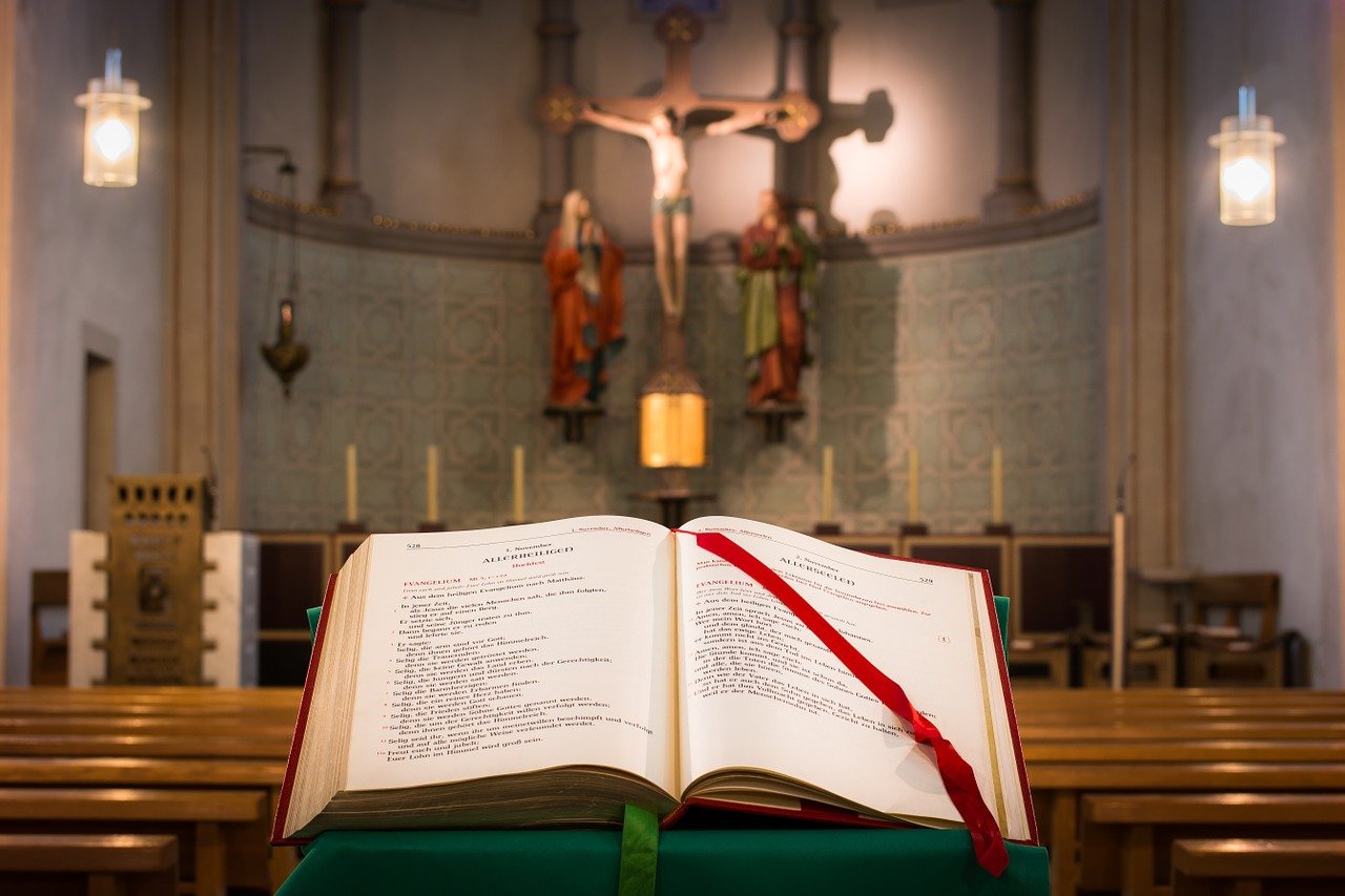carte de rugaciuni deschisa si asezata pe un stativ intr-o biserica
