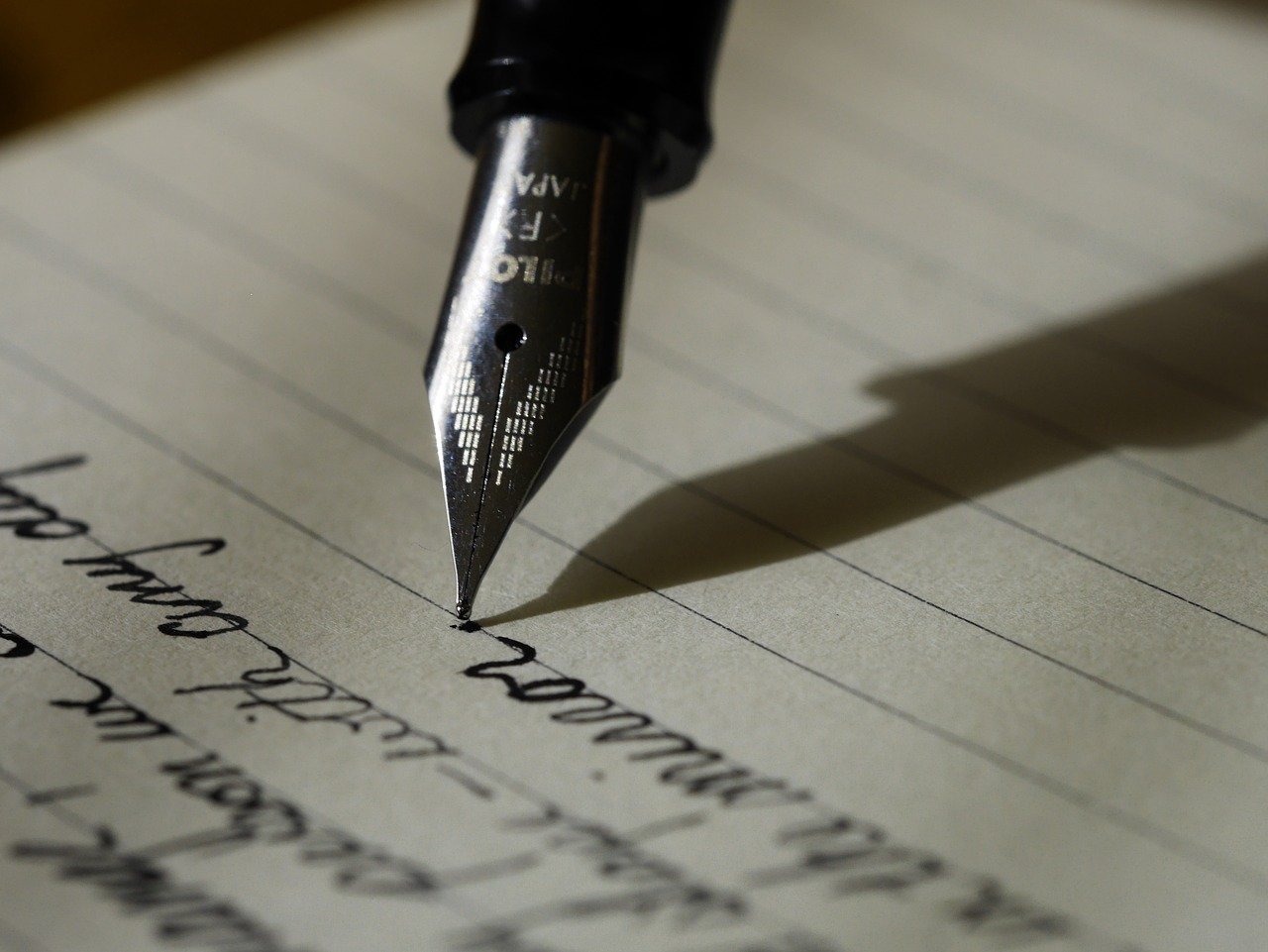 scrisoare si un stilou cu peniță cu cerneala neagra