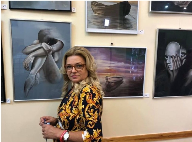ioana nitu alaturi de tablouri pictate