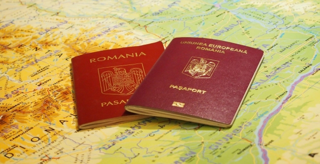 imagine cu pasapoarte romanesti asezate deasupra unei harti a lumii