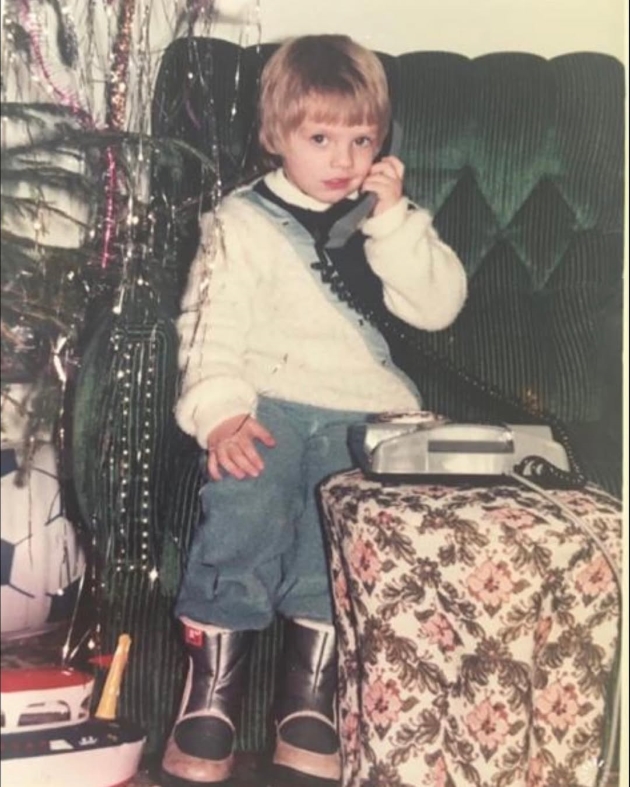 sebastian stan in copilarie cu un telefon fix in fata bradului de craciun 