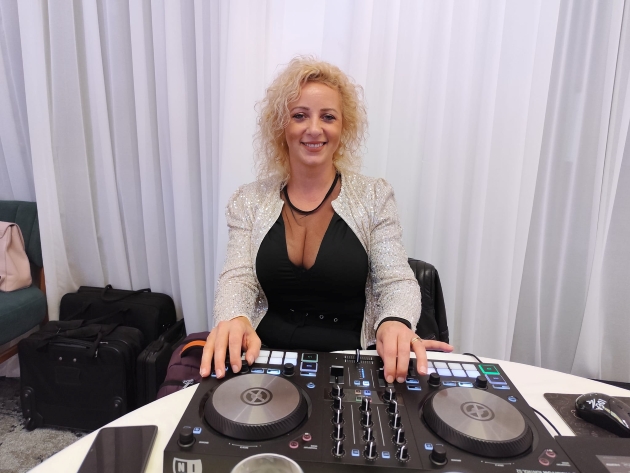 laura onila imbracata cu o bluza neagra manevreaza aparatura de dj