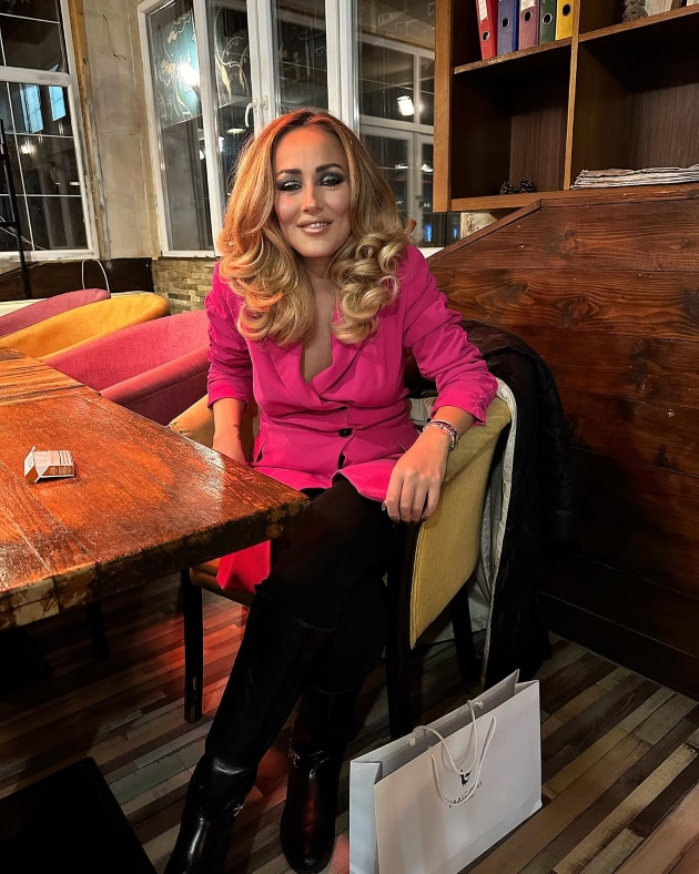 nidia moculescu blonda sta la masa imbracata cu o bluza roz