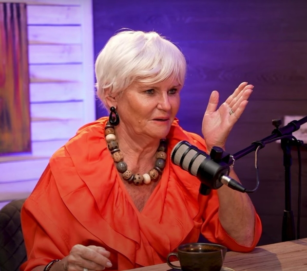 monica tatoiu la podcast imbracata cu o bluza portocalie