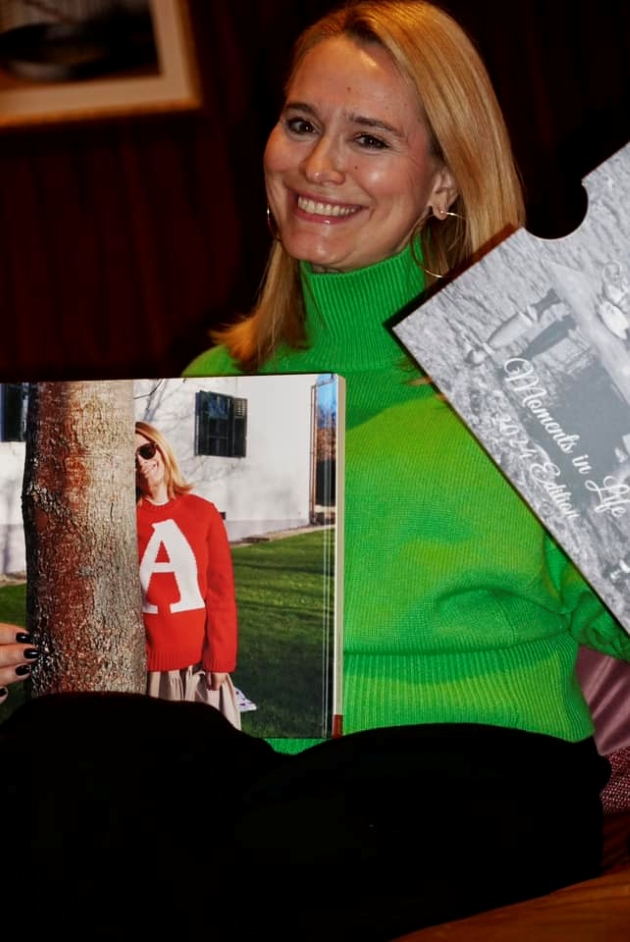 andreea esca imbracata cu un pulover verde tine in mana o revista