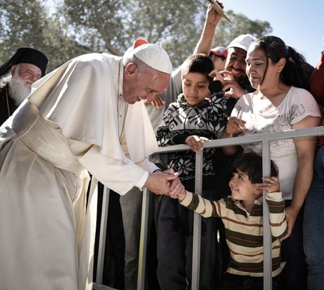 papa francisc inconjurat de oameni zambeste si da mana cu un copil