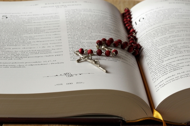 o biblie deschisa cu rozariu rosu in interior