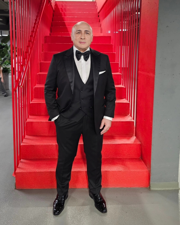 marcel pavel a avut o copilarie grea. fotografie cu marcel pavel imbracat la costum in fata unor scari rosii