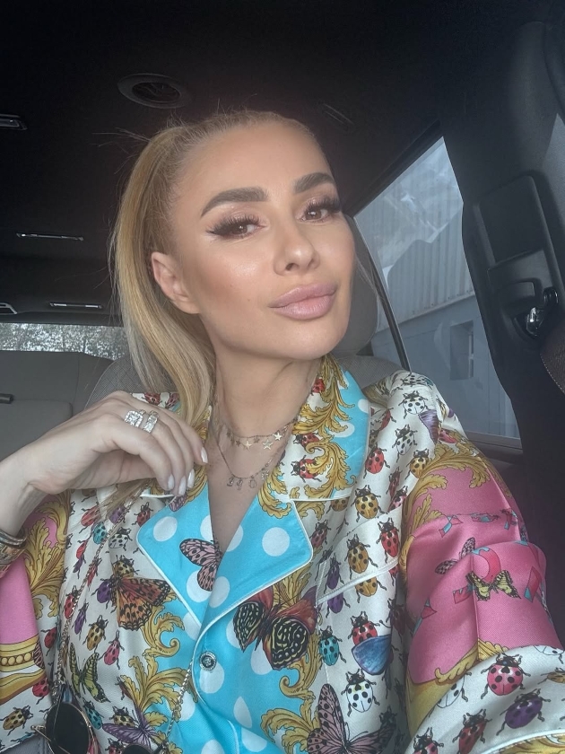 anamaria prodan in masina, imbracata cu o bluza multicolora