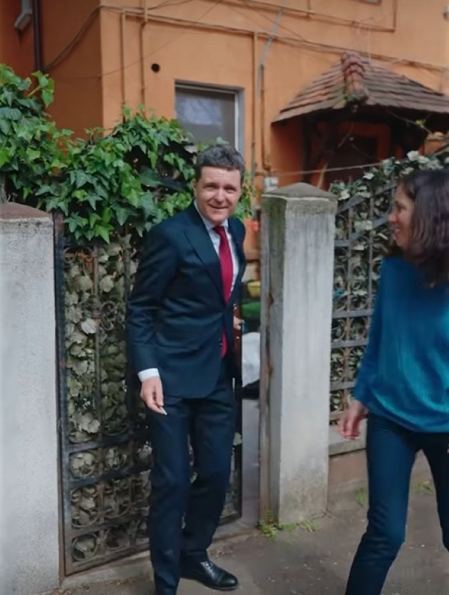 nicusor dan imbracat la costum in fata casei in care locuieste