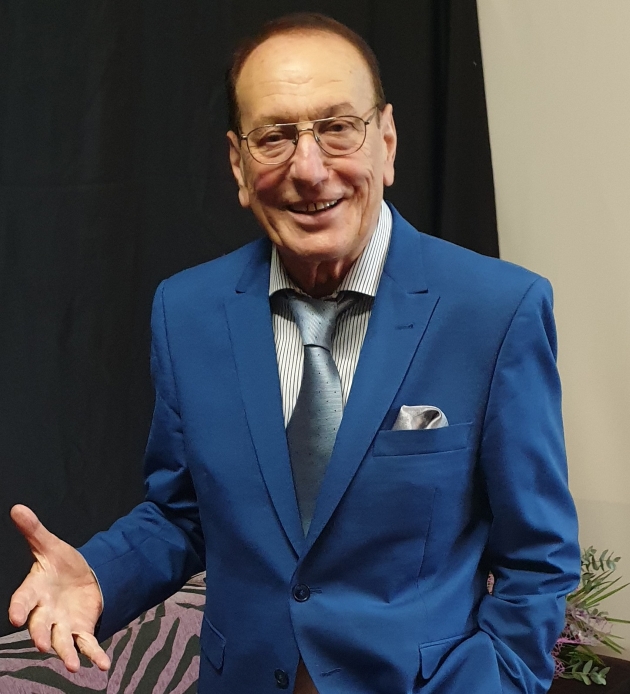 petre geambasu pozeaza imbracat intr-un costum albastru inchis