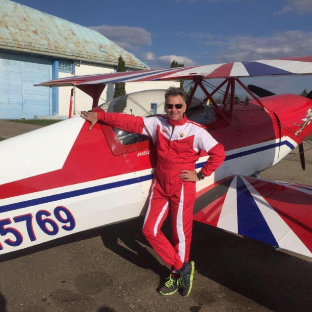 Sorin Bonchis în echipament de zbor pozează alături de un avion roșu