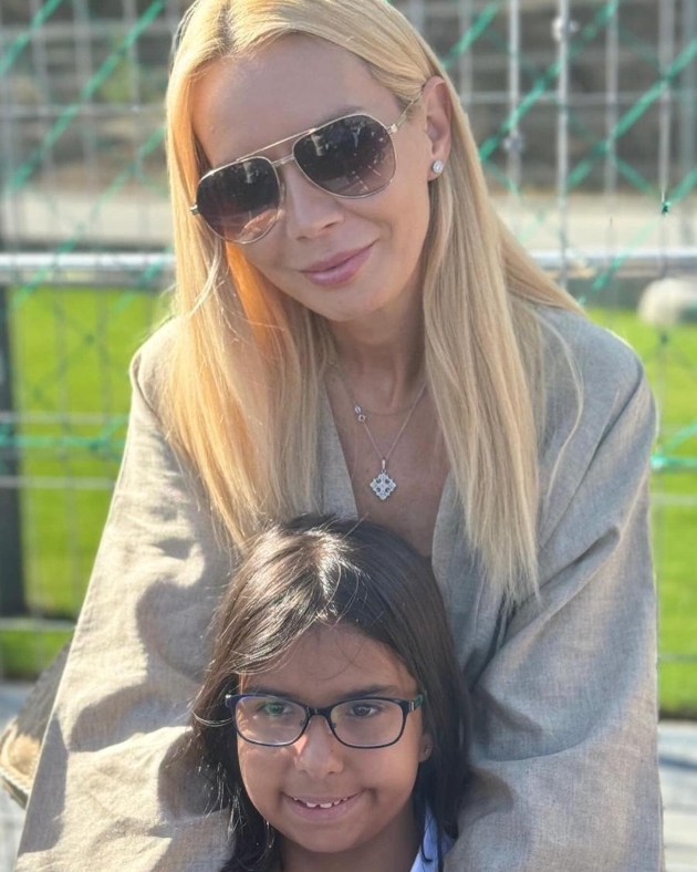 daciana sarbu cu ochelari de soare si bluza gri isi tine fiica, pe maria in brate