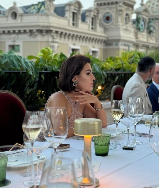 romina gingasu fotografiata stand la masa de ziua ei in timp ce se uita in departare