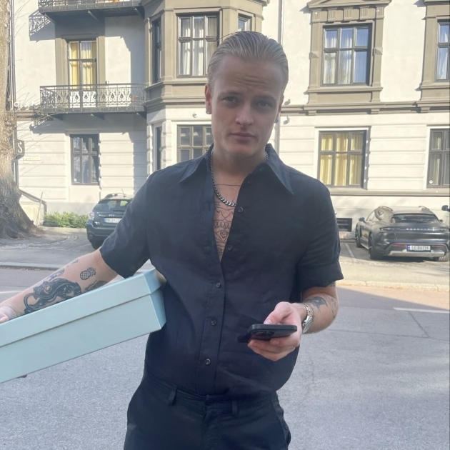 marius borg hoiby imbracat cu camasa si pantaloni negri se uita catre camera