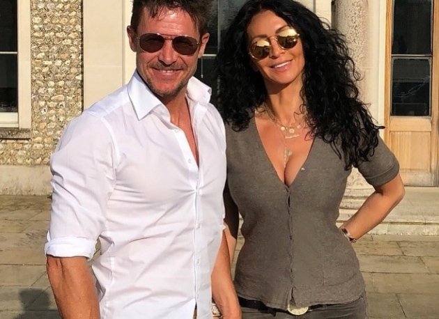 mihaela radulescu si felix baumgartner imbracati casual si cu ochelari de soare pozeaza in fata unei case