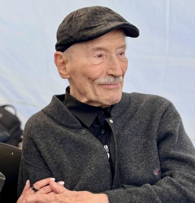 victor rebengiuc imbracat cu un pulover sport cu fermoar si sapca zambeste