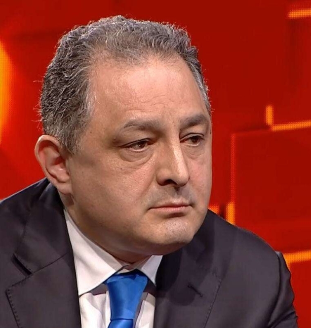 marian vanghelie la o emisiune tv imbracat la costum, funda rosu, se uita in fata