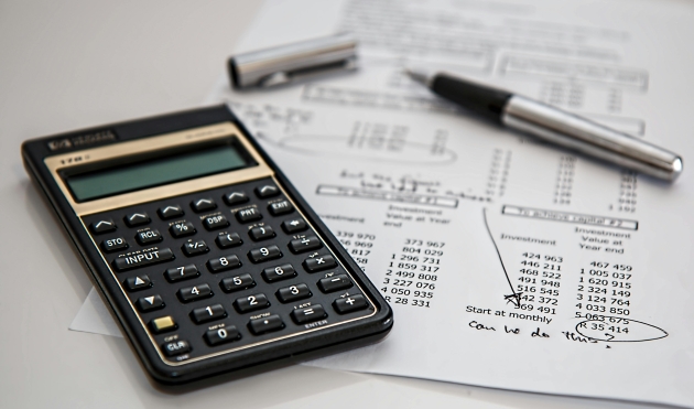 imagine cu calculator, stilou si foaie de calcul
