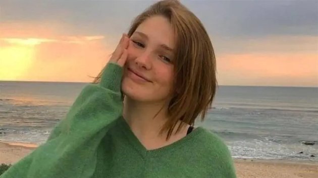 lital tunsa scurt imbracata cu un pulover verde zambeste