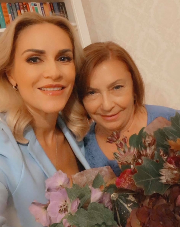 gabriela firea zambitoare alaturi de mama ei si un buchet de flori si frunze