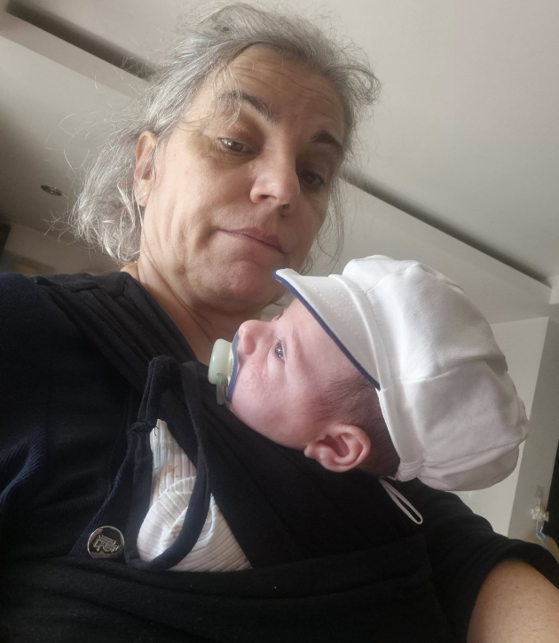 maia morgenstern imbracata in negru tinandu-si nepotul in brate