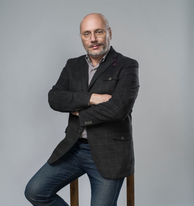 dr cristian andrei imbracat la costum sprijinit de un scaun sedinta foto