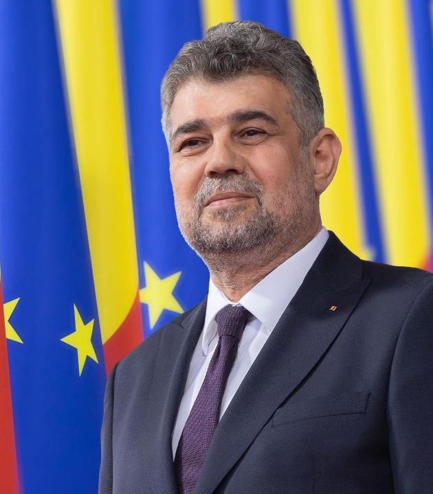 marcel ciolacu imbracat la costum fotografie pe fundal tricolor