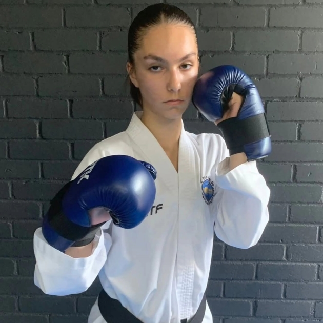 isabelle sava imbracata in costum de taekwondo si manusi cu o expresie determinata