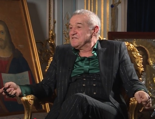 gigi becali imbracat la costum stand pe un fotoliu luxos in timpul unui interviu